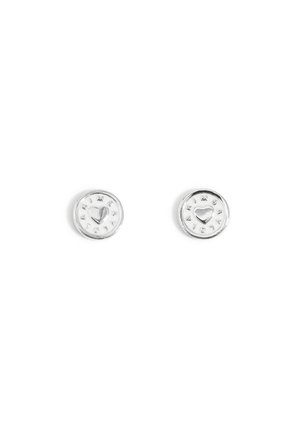 Boucles d'oreilles clous rondes en argent, chacune avec un cœur en relief au centre et un petit texte circulaire autour du bord sur fond blanc.