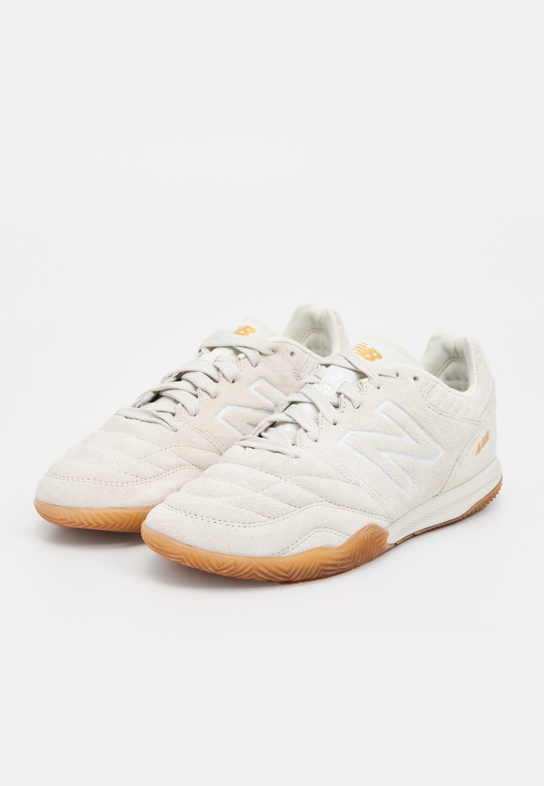 Witte suède sportieve schoenen met een textuurpatroon, rubberen gumzool en witte logo-accenten. Heeft een traditionele vetersluiting.