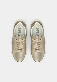 Beige leather sneakers with a textured pattern. Features golden metal eyelets and a white rubber sole. Branding on the insole.