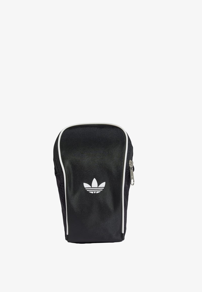 Fekete sporttáska fényes felülettel, fehér cipzárral és ikonikus fehér logóval. Szellőző hálós oldalai és karcsú, kompakt dizájnja van.