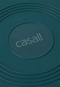 Zielona okrągła mata z koncentrycznymi pierścieniami i napisem "casall" w jasnoszarym kolorze na środku, wykonana z teksturowanego materiału.