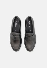 Mocassins noirs en cuir à enfiler avec une large bride sur le dessus, taille 4½, marqués "Gabor" à l’intérieur de chaque chaussure, sur fond blanc.