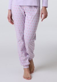 Pantaloni da pigiama viola chiaro con piccolo motivo floreale rosso, vita elastica e polsini alle caviglie. Tessuto di cotone morbido.