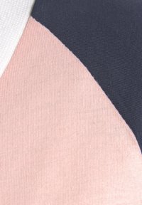 Farbblockierter Stoff in Rosa, Weiß und Marineblau. Glatte Textur, weiches Strickmaterial, saubere Kanten und ausgeprägte geometrische Muster.