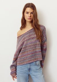 Kötött pulóver vállakat szabadon hagyó kialakítással, pasztell árnyalatokban pompázó, több színű, texturált mintával. Világoskék farmerrel párosítva.