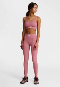 Rosa ribbad sport-bh och högmidjade leggings, gjorda av stretchtyg, med en figurnära design och logotypdetaljer på midjebandet.