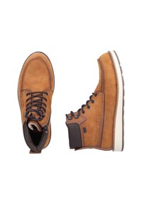 Bruine leren laarzen met donkere accenten. Kenmerken zijn onder andere veters, een ronde neus, een gestructureerd oppervlak en contrasterende rubberen zolen.