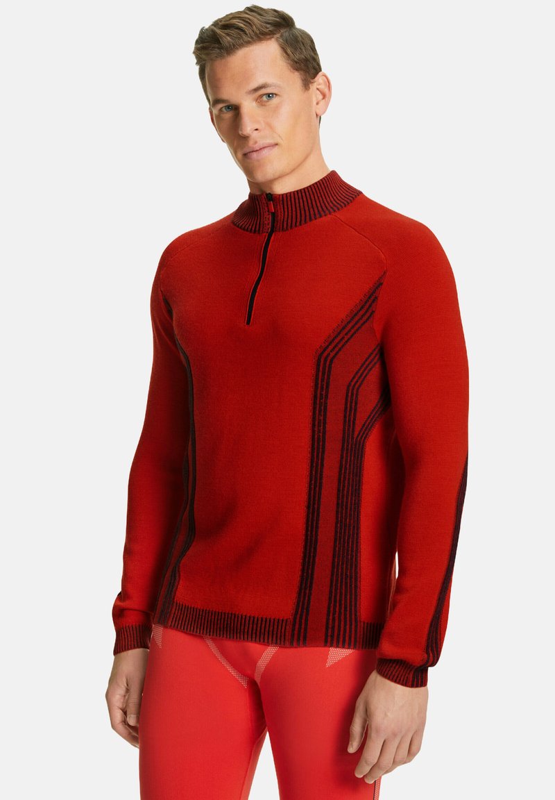 Pull en tricot rouge avec un col haut, fermeture éclair mi-hauteur à l'avant, et des rayures verticales noires contrastantes sur les côtés. Texture lisse et design ajusté.