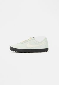 Πράσινα παπούτσια με λείo επάνω μέρος, μαύρη σόλα και καφέ κορδόνια. Διαθέτουν διακριτικό λογότυπο σε κρεμ απόχρωση στο πλάι και στρογγυλεμένη μύτη.