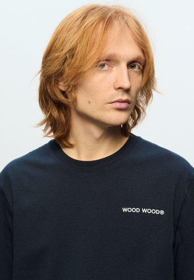 Mørkeblå sweatshirts lavet af bomuld, med rund hals, lange ærmer og et hvidt "WOOD WOOD®" logo på brystet. Glat tekstur med en afslappet pasform.