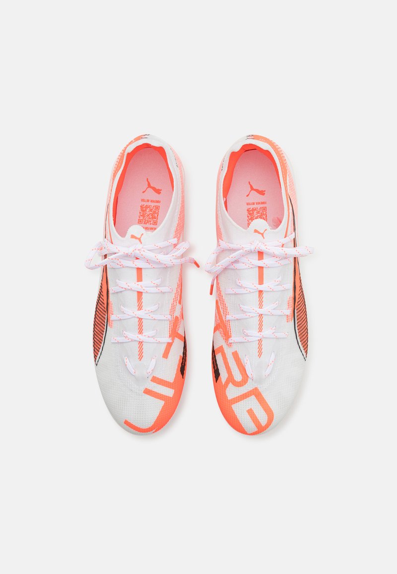 Chaussures de sport avec une tige en mesh blanc, accents orange et détails noirs, design texturé, lacets plats et un logo audacieux.
