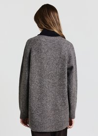 Grauer, gestrickter Pullover mit lockerem Sitz, langen Ärmeln, gerippten Bündchen und einem etwas längeren Rückensaum. Weiche Textur mit einer Mischung aus Fasern.