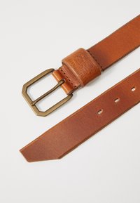 Curea de piele maro cu o cataramă dreptunghiulară din alamă, având margini cu un finisaj neted și un accent texturat aproape de cataramă.