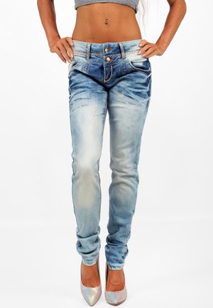 Jeans aderenti in denim blu sbiadito con vita alta, dotati di doppi bottoni, cuciture a contrasto e delicate sfumature di usura.