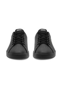 Čierne kožené tenisky s okrúhlou špičkou, textúrovaným povrchom, plochými šnúrkami, perforovanými detailmi a gumovou podrážkou. Branding na jazyku a boku.