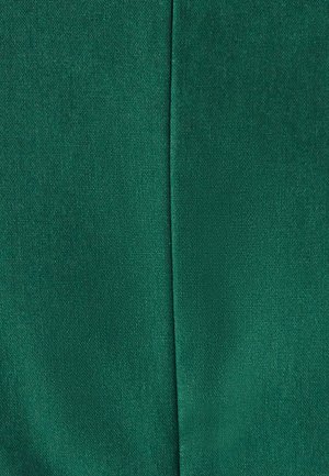 Teal groene stof met een zichtbare verticale naad die door het midden loopt, wat de gestructureerde geweven materiaal toont.