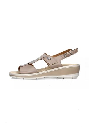 Sandali con tacco a cuneo beige, con punta aperta, cinturino regolabile con fibbia e accenti metallici nella parte superiore. Sottopiede testurizzato per il comfort.