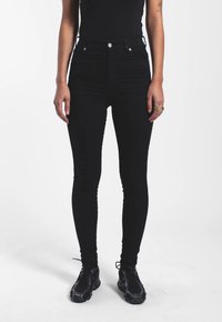 Černé vysoké skinny džíny, jejichž součástí je pět kapes, kovové prvky a hladká, mírně elastická tkanina pro maximální pohodlí.