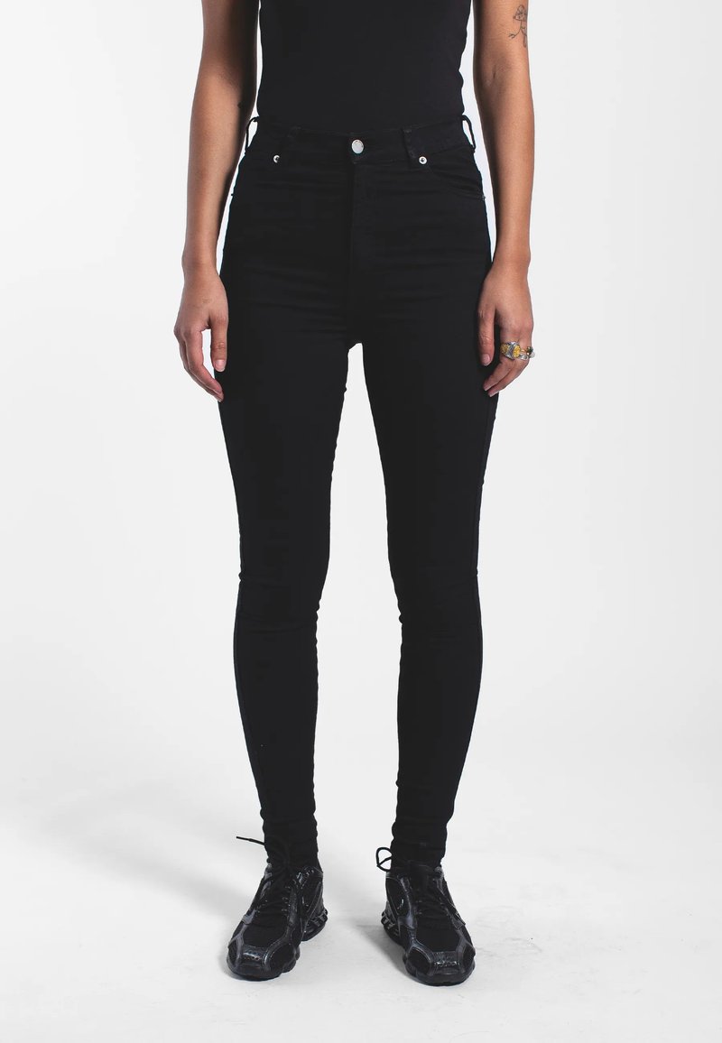 Černé vysoké skinny džíny, jejichž součástí je pět kapes, kovové prvky a hladká, mírně elastická tkanina pro maximální pohodlí.