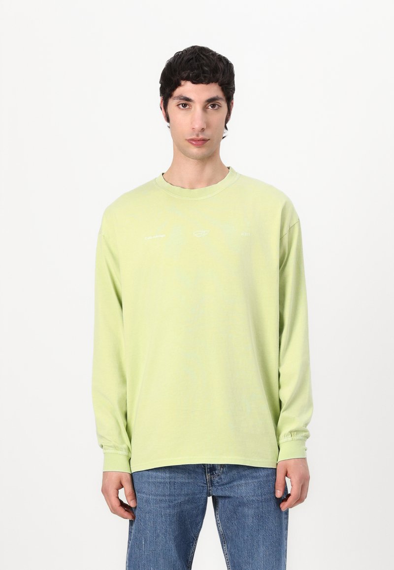 Light green long-sleeve t-shirt in soft cotton, featuring a crew neckline and elastic cuffs. Minimalist design with subtle white text accents.