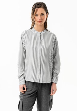 Striped long-sleeve shirt in white and gray, featuring a mandarin collar and button front closure, paired with gray cargo pants.