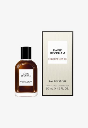 Bouteille de parfum en verre brun avec un capuchon noir, dotée d'une étiquette blanche. Accompagnée d'une boîte en carton texturé avec un design noir et blanc.