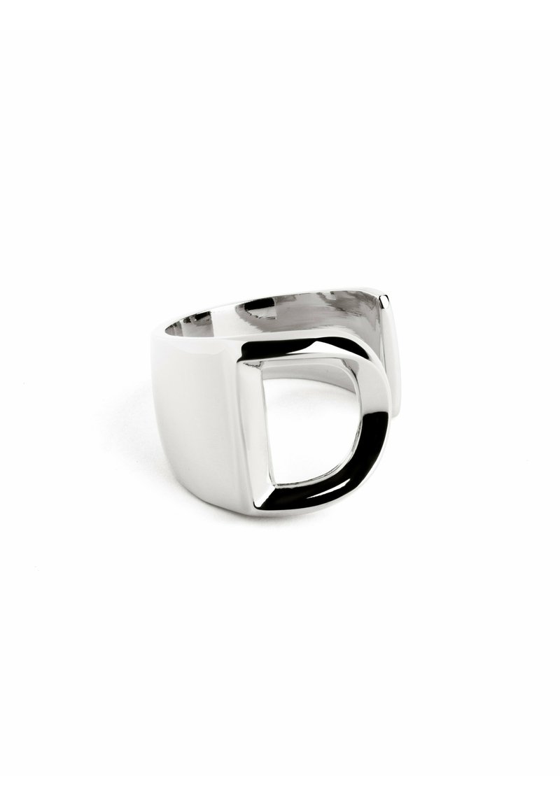 Anello in metallo argentato con un design ritagliato unico, finitura lucida e bordi arrotondati lisci, che unisce estetiche moderne e forme geometriche.