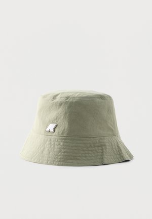 Lichtgroene bucket hat met gestikte rand en een klein wit logoplaatje aan de zijkant tegen een effen achtergrond.