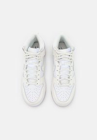 White leather high-top sneakers with perforated toe box, flat laces, and a grey accent. Interior lined with soft fabric. Rubber sole.