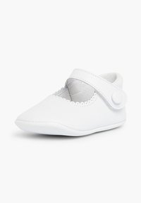 Witte leren schoen met een ronde neus, geschulpte rand en een zijwaartse klittenbandsluiting voor een veilige bevestiging. Gladde textuur en minimalistisch ontwerp.