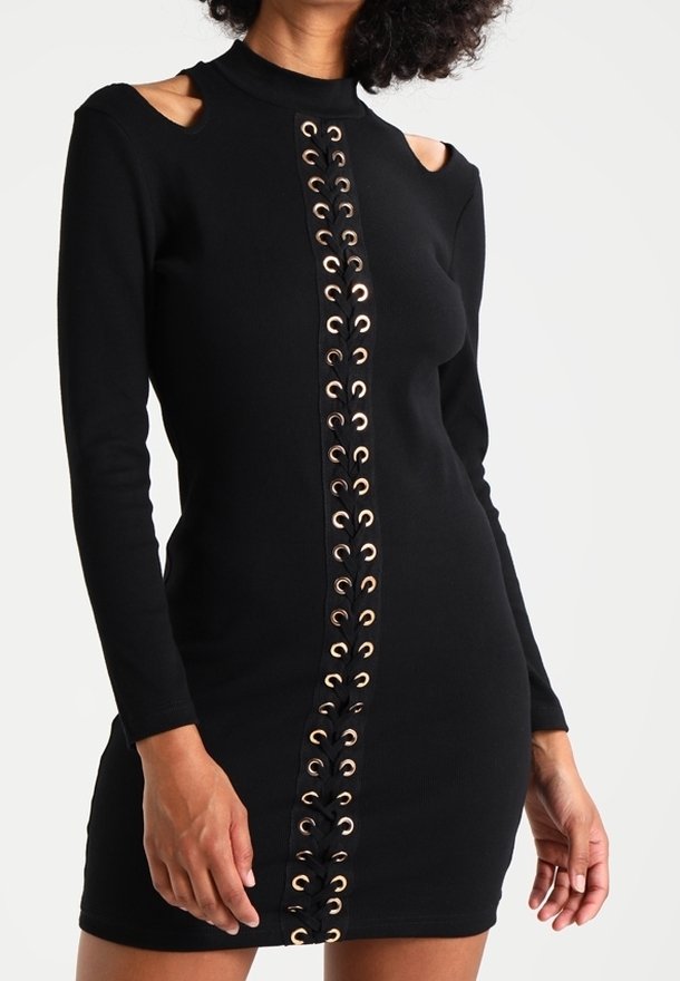 Svart långärmad klänning med utskurna axlar, med ett snörningsdetalj framtill med guldfärgad ögla. Åtsittande, tillverkad av stretchigt tyg.