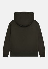 Tamsiai žalias gobtuvas, dėvimas su lygaus audinio, su raukšlėtam rankogaliams ir laisvu kirpimu. Atgalinis vaizdas nerodo jokio matomo aparatūros ar raštų.