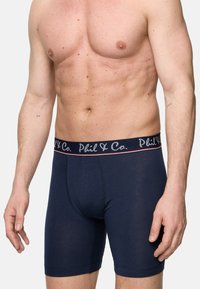Marinblå boxershorts med ribbad elastisk midjeband som har "Phil & Co."-logotypen. Slätt tyg, åtsittande form och midjehöjd.