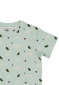 Ljusblå t-shirt med tryck av bin, fjärilar och myror, mot en bakgrund av vita moln. Tillverkad av mjukt tyg med rund halsringning.