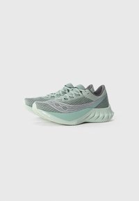 Baskets de course vert clair avec un dessus en maille texturée, accents gris et une semelle flexible dotée de rainures distinctives pour une meilleure adhérence.