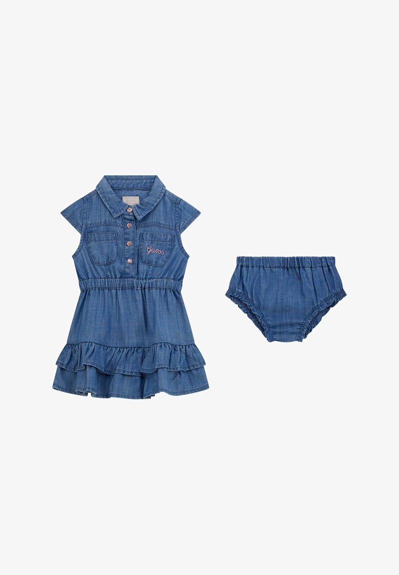 Rochie din denim cu mâneci scurte, guler și tiv volăntat. Include pantaloni scurți asortați cu volănt. Material albastru cu broderie "Guess".