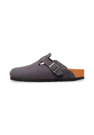 Zueco de color gris oscuro tipo slip-on con parte superior de ante, correa con hebilla ajustable, plantilla de corcho y suela negra mostrado de lado.