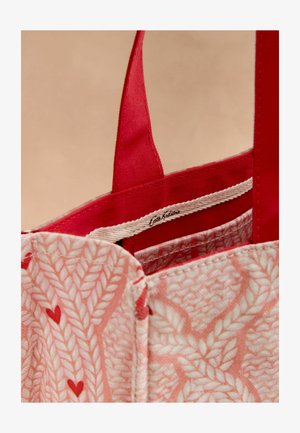 Růžová taška přes rameno s listovým vzorem, červenými popruhy a vnitřním podšívkou. Obsahuje logo štítek uvnitř a měkkou texturu tkaniny.