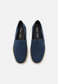 Marine lærred slip-on sko med en vævet jute sål, der har et korssting design og en blød foring. Brandlogo på indersålen.