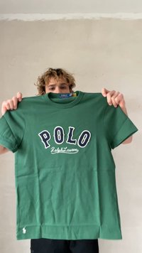 Πράσινο βαμβακερό μπλουζάκι με το κείμενο "POLO Ralph Lauren" σε λευκό και ναυτικό μπλε. Με κοντά μανίκια, στρογγυλή λαιμόκοψη και μικρό λογότυπο στο κάτω αριστερό μέρος.