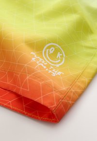 Colorful shorts in yellow to orange gradient, made of smooth fabric. Features geometric pattern and white text graphic with a smiley face.