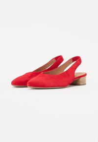 Scarpe slingback in suede rosso con punta rotonda, piccolo tacco impilato e design aperto sul retro per facilitare l'indossamento.