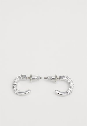 Brincos de argola em prata com um design curvado polido, adornados com detalhes estriados e pinos metálicos para um fecho seguro.