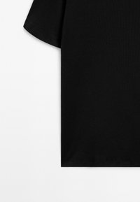 Zwart katoenen T-shirt met korte mouwen weergegeven tegen een witte achtergrond, waarmee de rechterzijde en mouwrand zichtbaar zijn.
