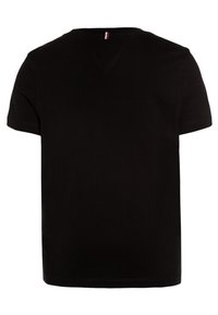 T-shirt nera a maniche corte in cotone. Presenta un collo rotondo e una piccola etichetta colorata sul retro del collo. Senza fantasie o grafiche.