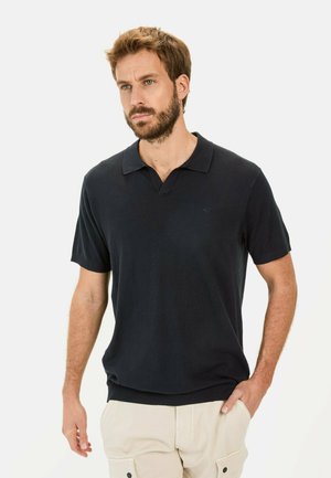 Navyblauwe polo met korte mouwen van zachte stof, met een klassieke kraag en een geribbelde zoom. Subtiele branding boven de linkerkant van de borst.
