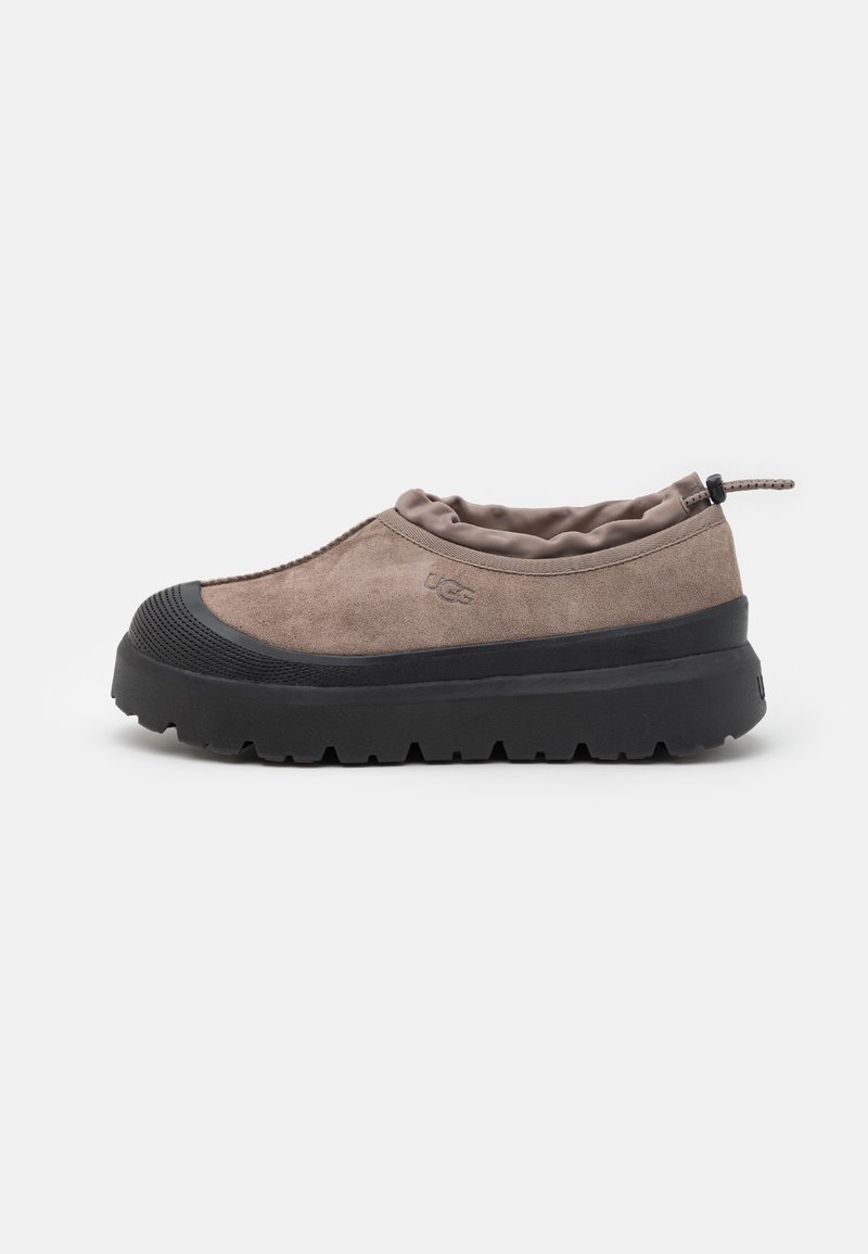Slip-on shoes with a brown suede upper and black rubber sole. Features a padded collar and textured toe cap. Lightweight, with a streamlined design.