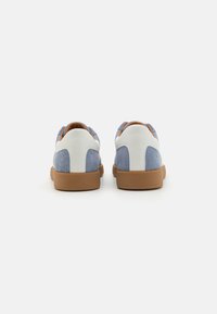 Blå ruskindsneakers med hvide læderdetaljer, tan gummisåler og orange accenter. Lavtops design med en tekstureret finish.