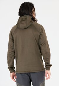 Olijfgroene hoodie met lange mouwen, een gladde textuur en geribbelde manchetten. Heeft een naadloos ontwerp en een praktische pasvorm aan de onderkant.