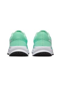 Baskets avec une tige en mesh vert menthe respirant, semelle blanche et semelle extérieure noire texturée. Logo Nike subtilement présent sur le côté.